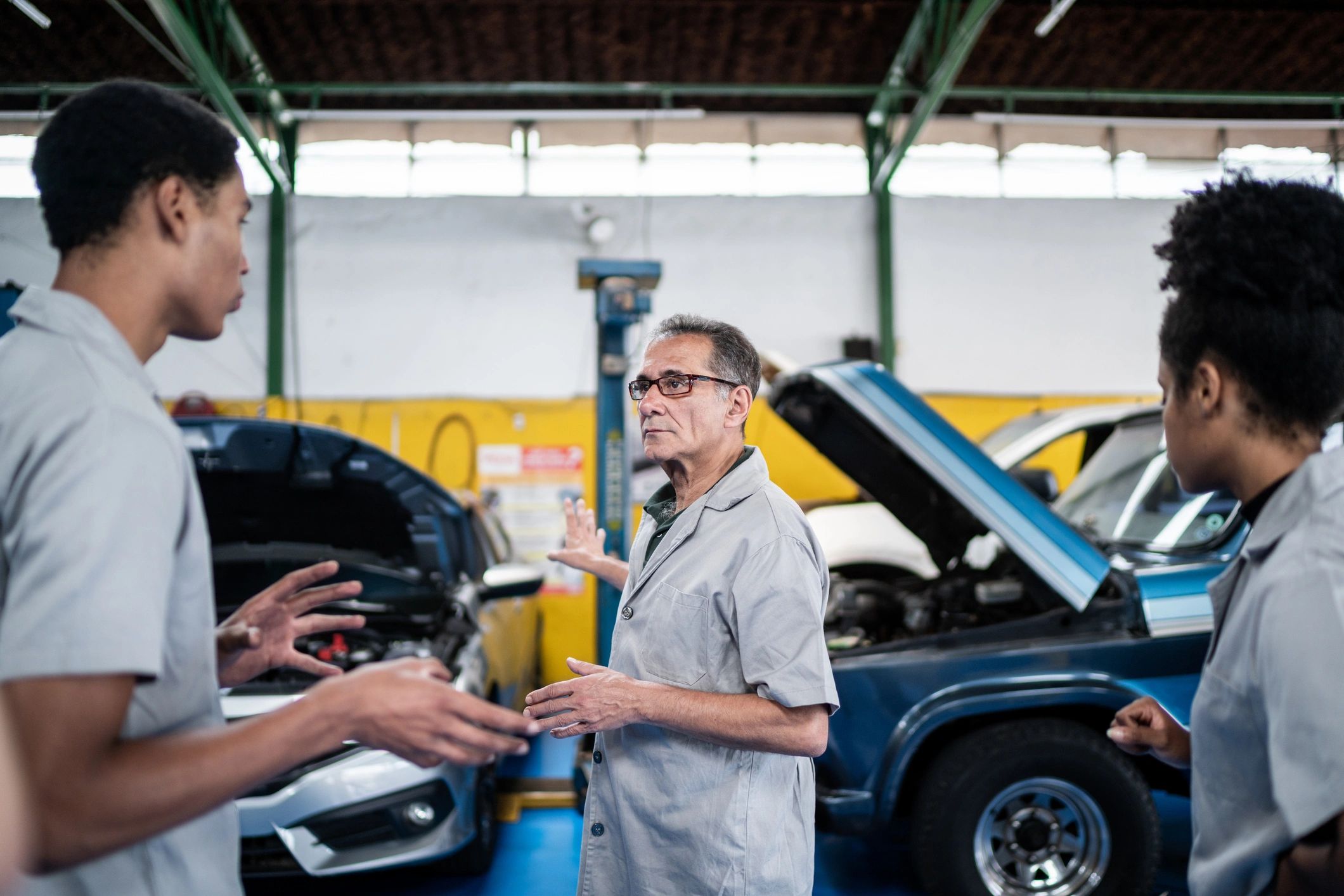 Mechanics discussing work in an auto repair shop