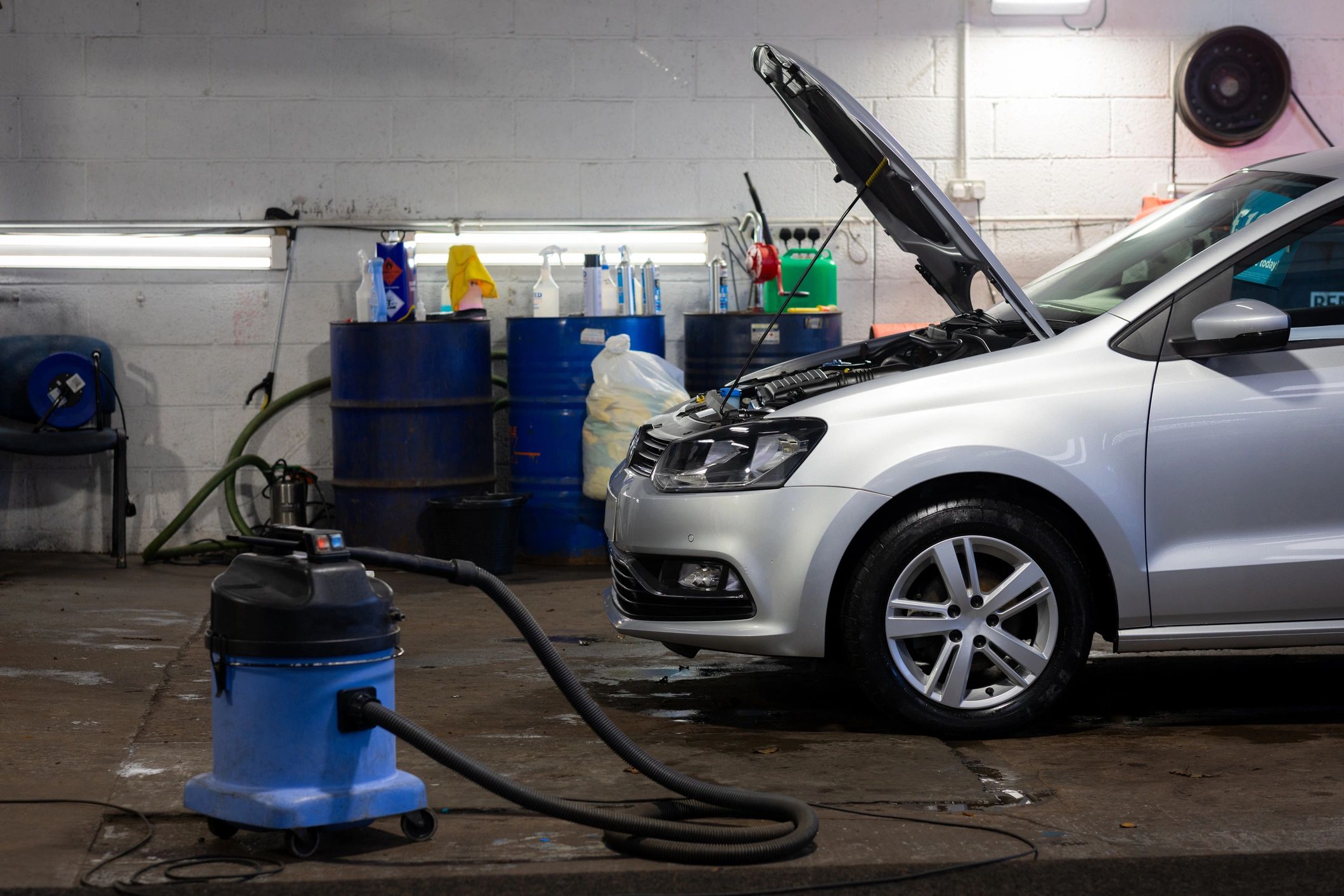 Car being serviced inside a garage with tools nearby