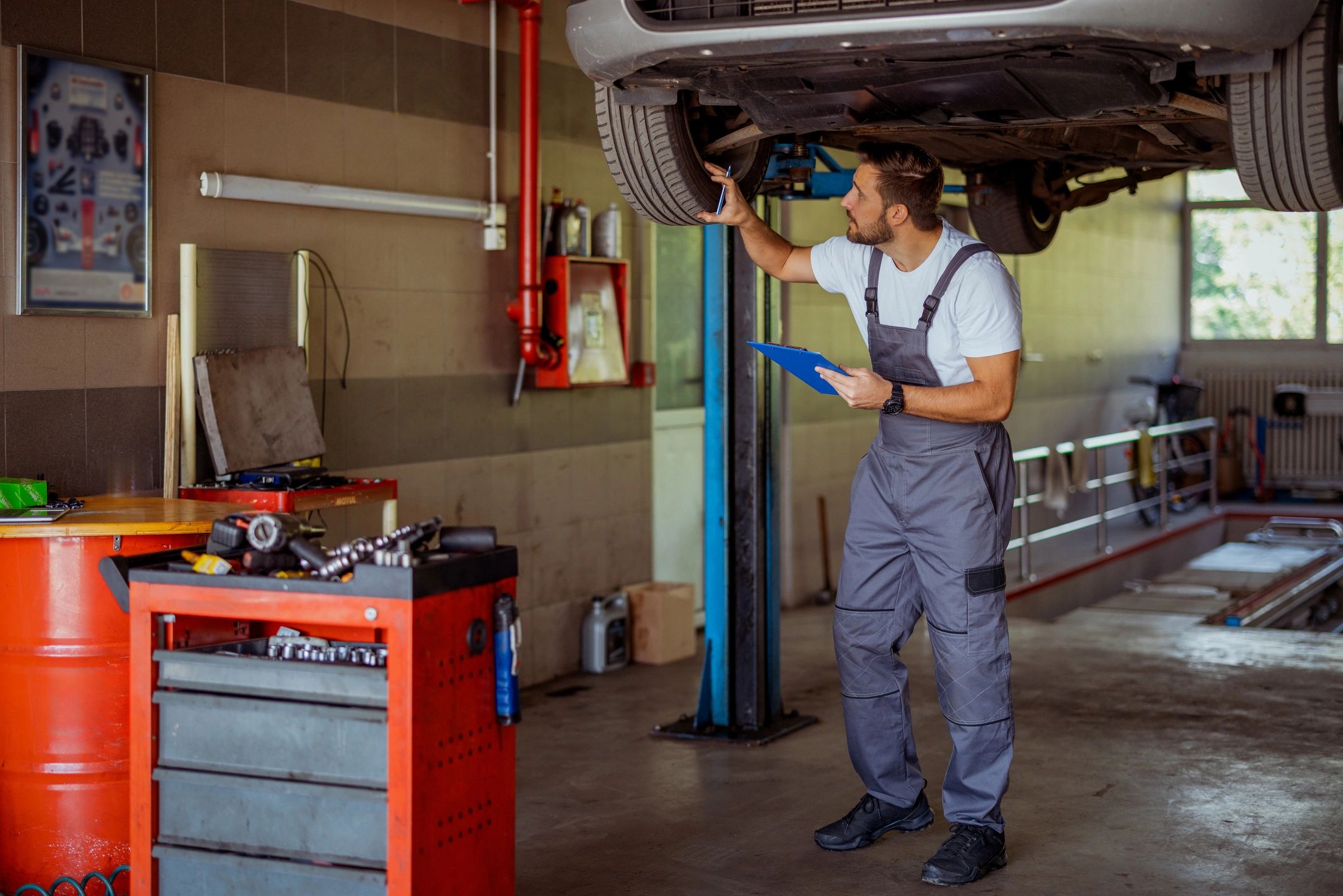 Mechanic using a clipboard while servicing a car